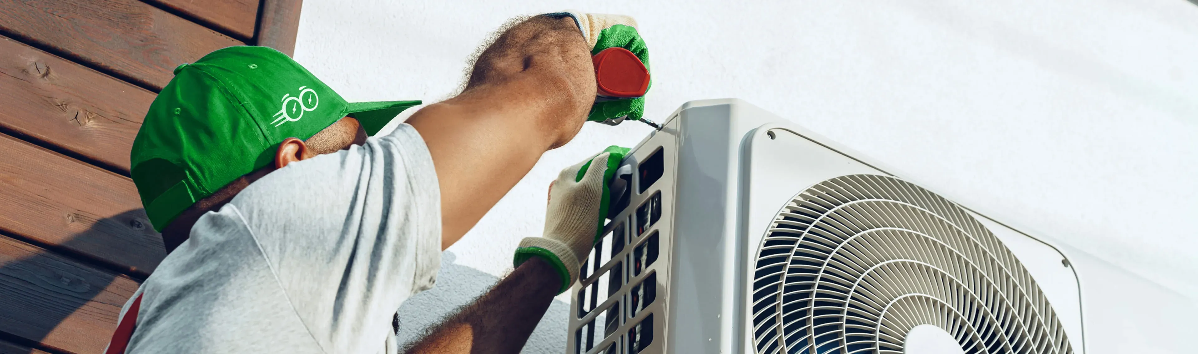 Rapid Response team member securing an outdoor AC condenser unit to the wall during installation service