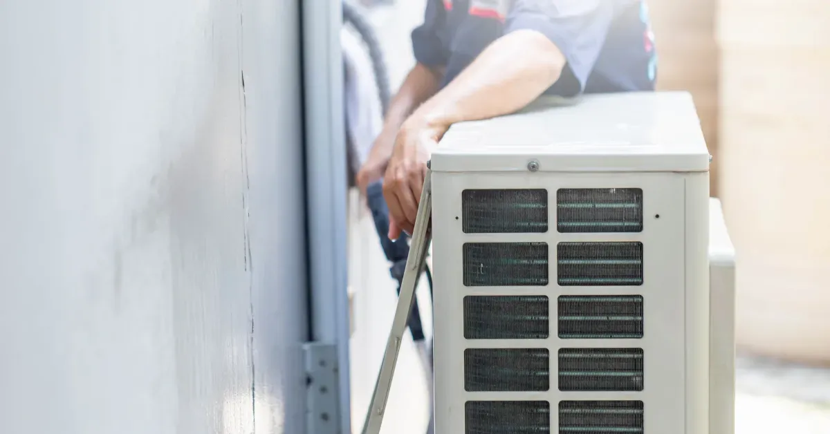 A technician is positioning an outdoor AC unit and securing the lines for proper installation and stable operation