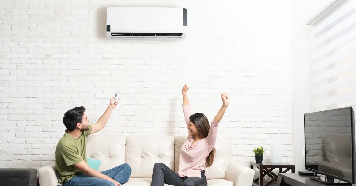 A couple relaxing under an A/C unit in the living room