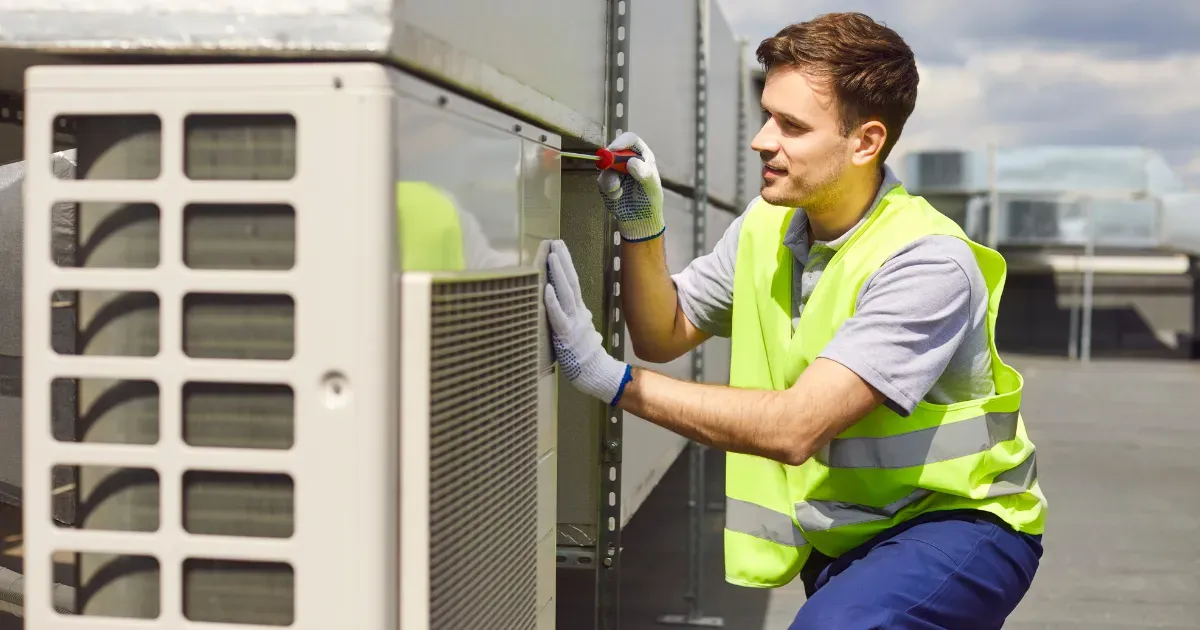 Rapid Response AC technician cleaning and servicing an indoor wall-mounted air conditioning unit